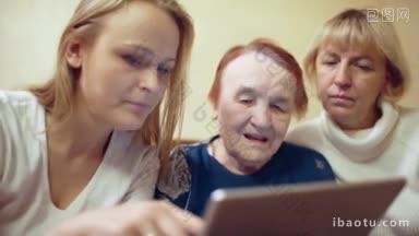 年轻女子用平板电脑向她的母亲和年迈的祖母展示照片或视频的多莉照片